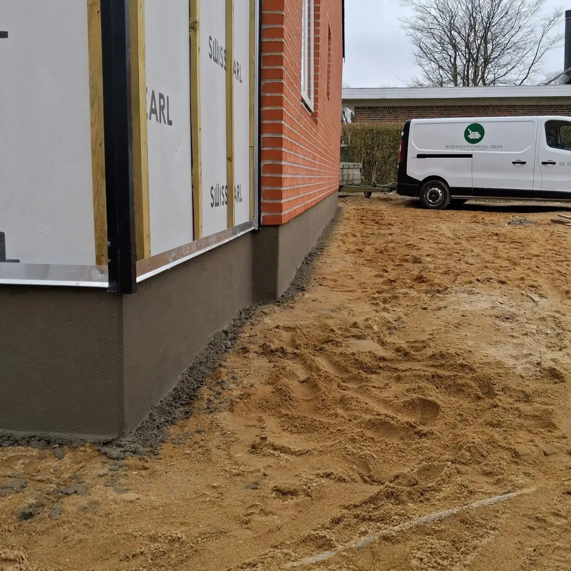 Murermester Mikkel Green udfører professionelt murerarbejde på udendørs projekter.